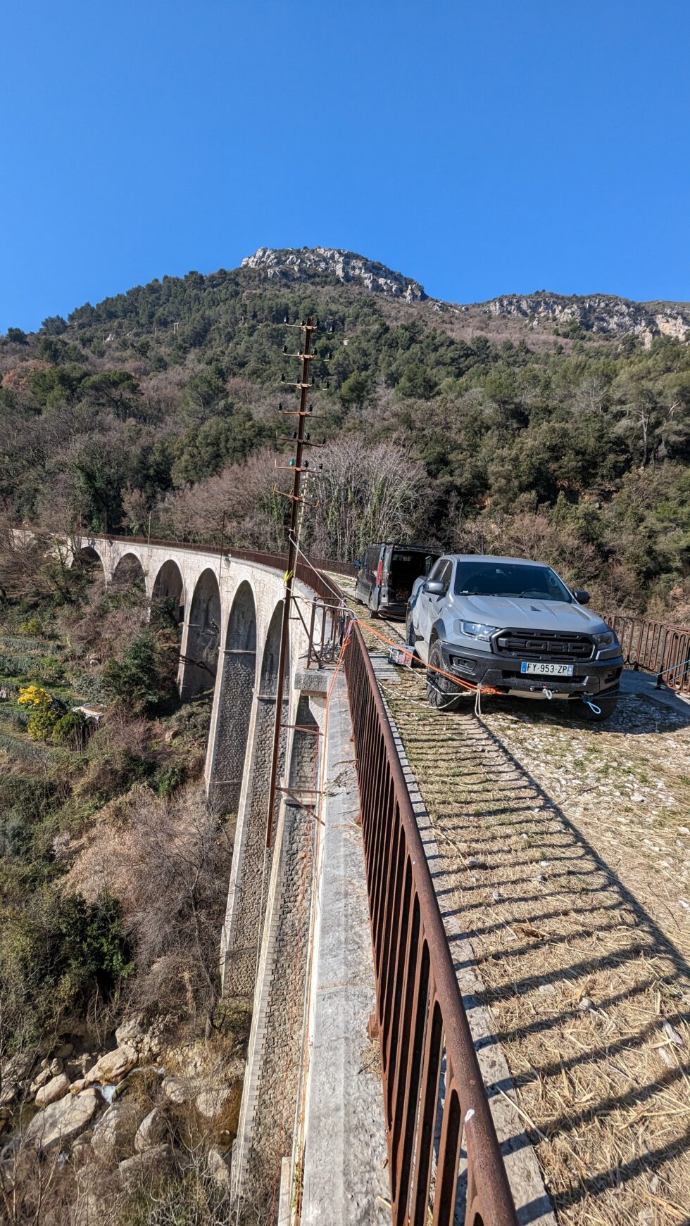 Vue d’ensemble de l’ancien pont ferroviaire en pierre de Saint-Jeannet avec les véhicules et les cordes du chantier