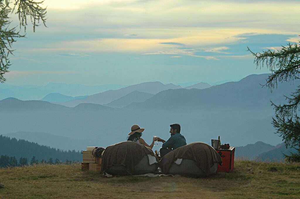 Couple trinquant devant les montagnes au coucher du soleil