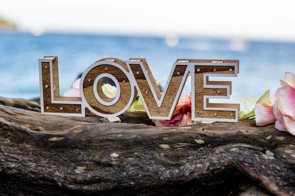 Lettres LOVE et fleurs dans un décor romantique face à la mer