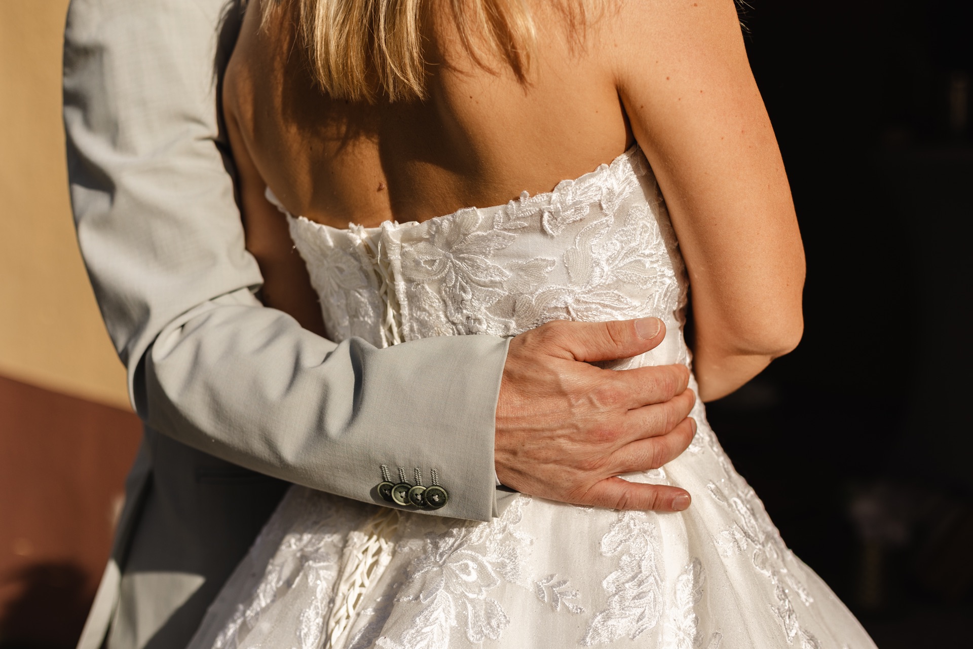 Main du marié posée sur la robe de sa partenaire pendant leur elopement