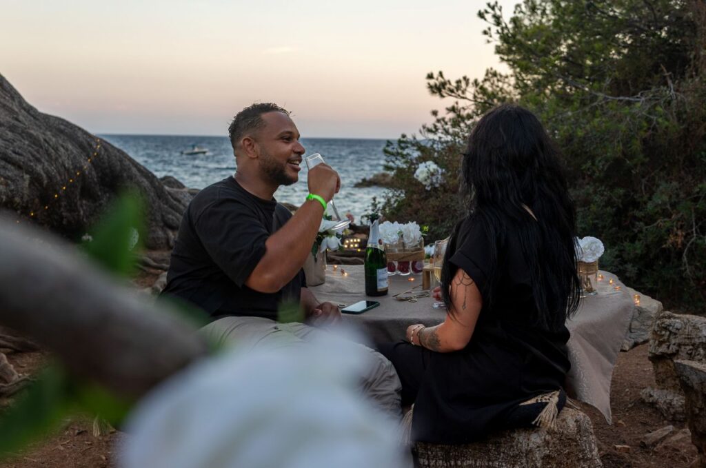 Couple partageant un apéritif au champagne dans un décor en bord de mer