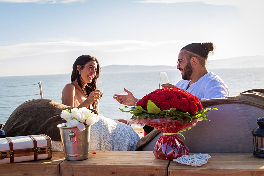 Couple au champagne avec des roses dans un décor de pique-nique à Cap-d’Ail