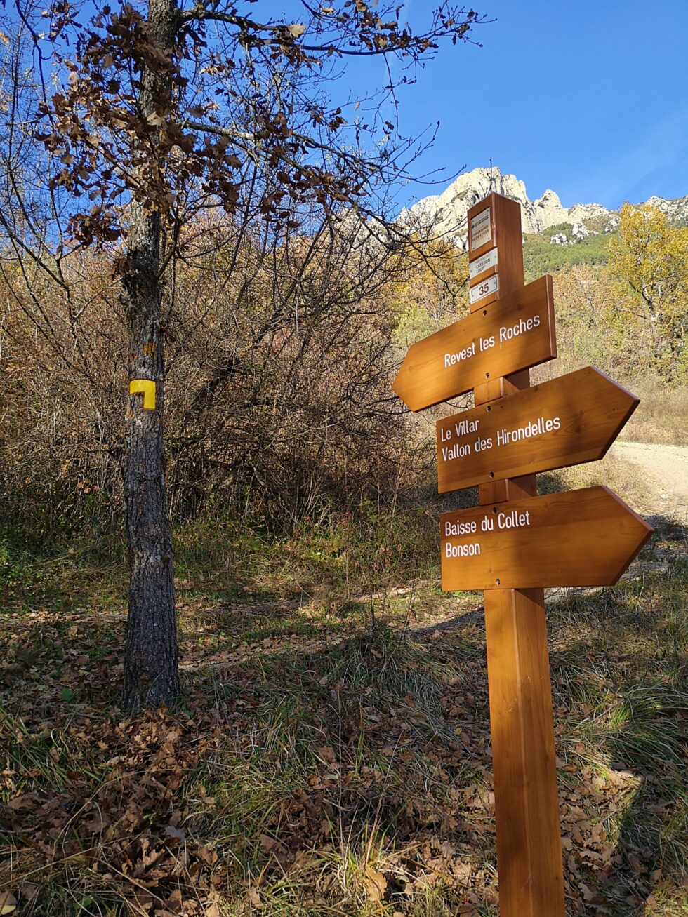 Poteau directionnel de randonnée indiquant Revest-les-Roches, Le Villar et Bonson.