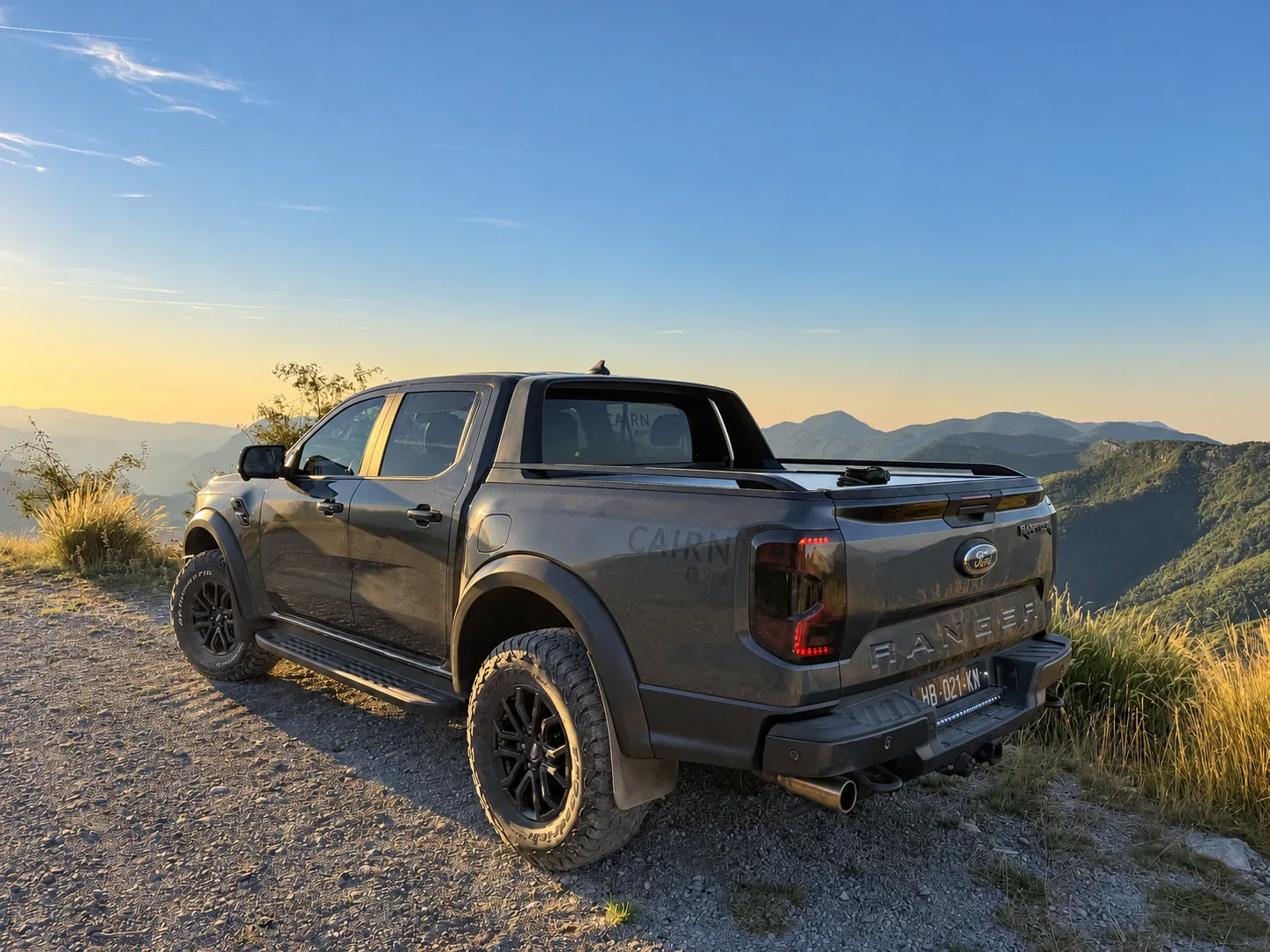 4x4 CAIRN Expe vu de dos devant les reliefs à la lumière dorée.