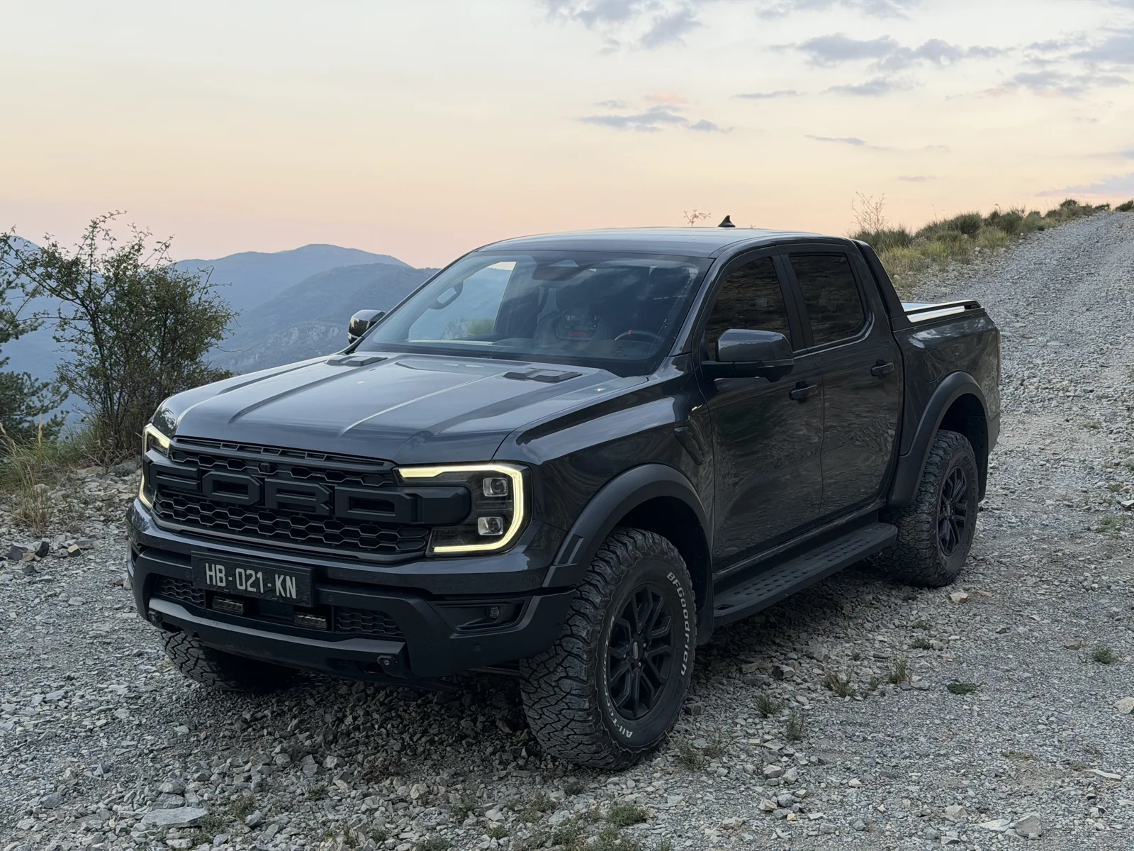 4x4 de face sur une piste rocheuse, avec les montagnes en arrière-plan.