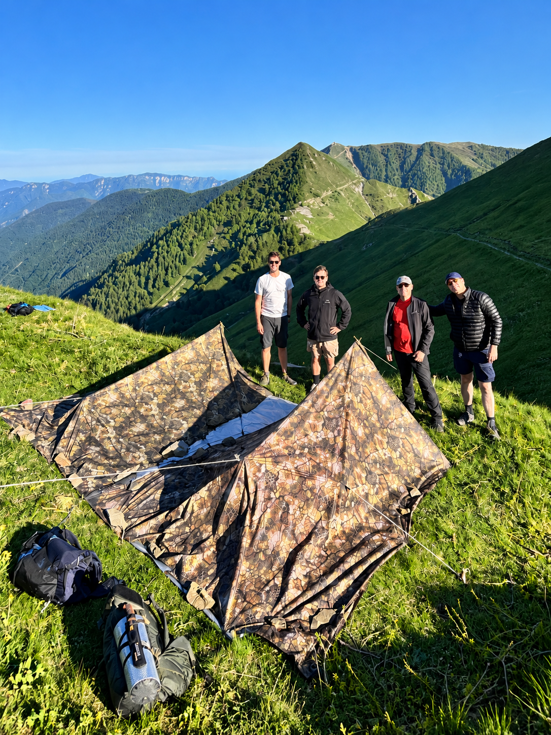Quatre participants près de leurs abris de bivouac en montagne
