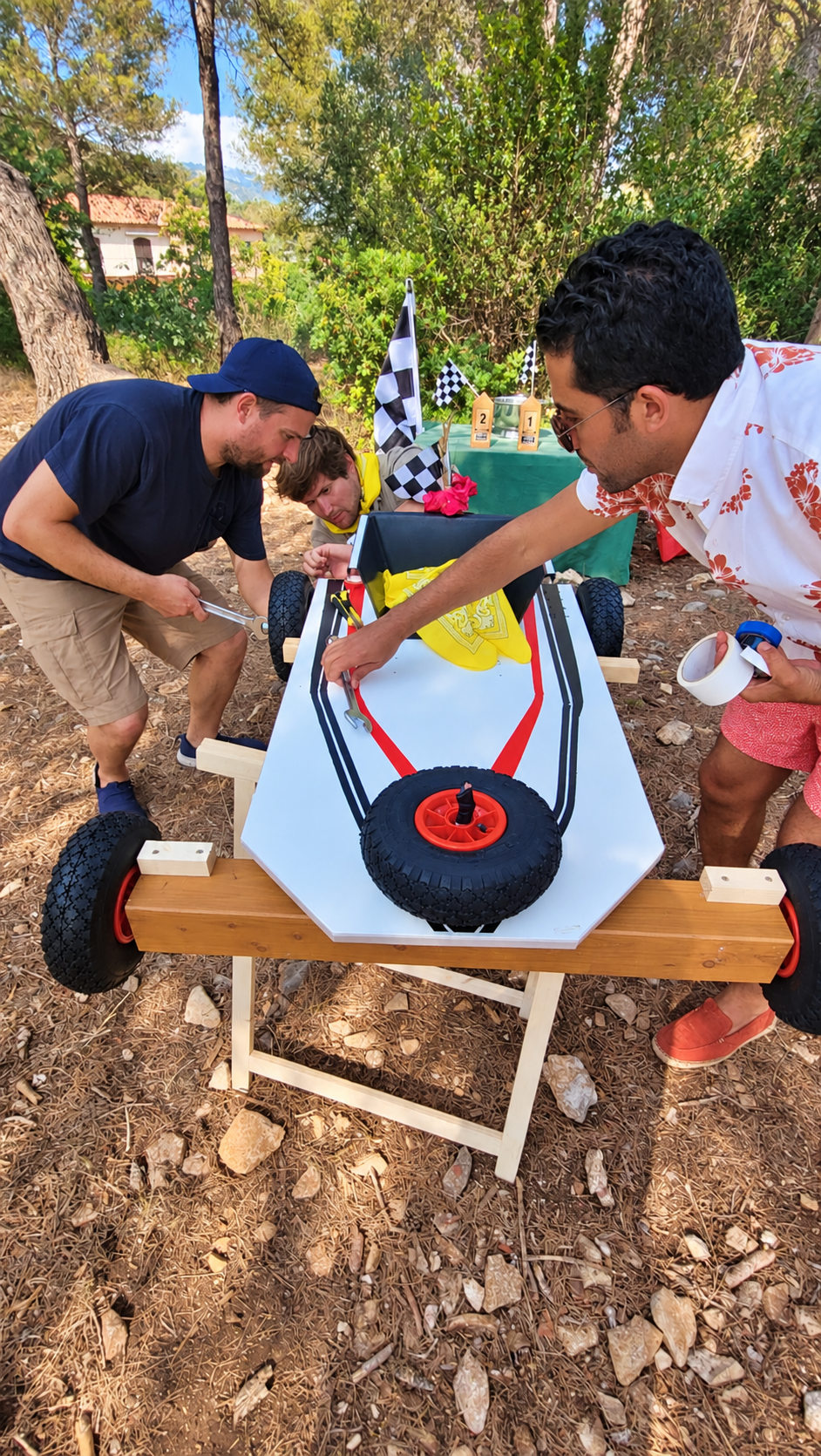 Participants décorant ensemble une carriole avec des motifs rouges, bleus et noirs.
