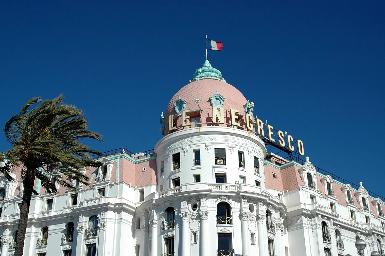 Façade et dôme de l’hôtel Negresco sous un ciel bleu.