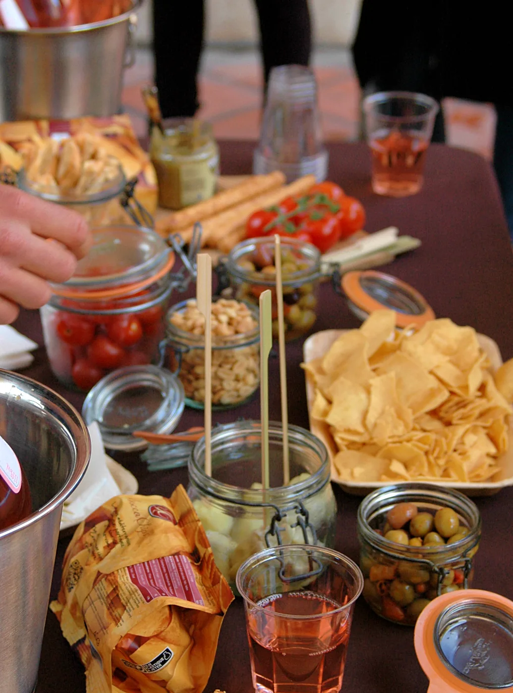 Table d’apéritif avec chips, olives, légumes et boissons.